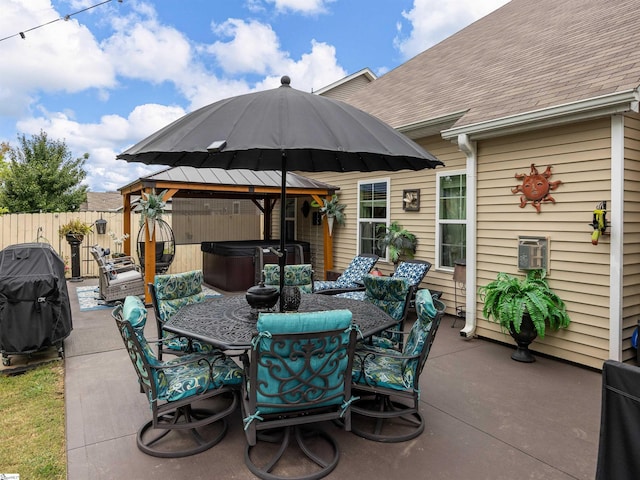 view of patio with area for grilling and a hot tub