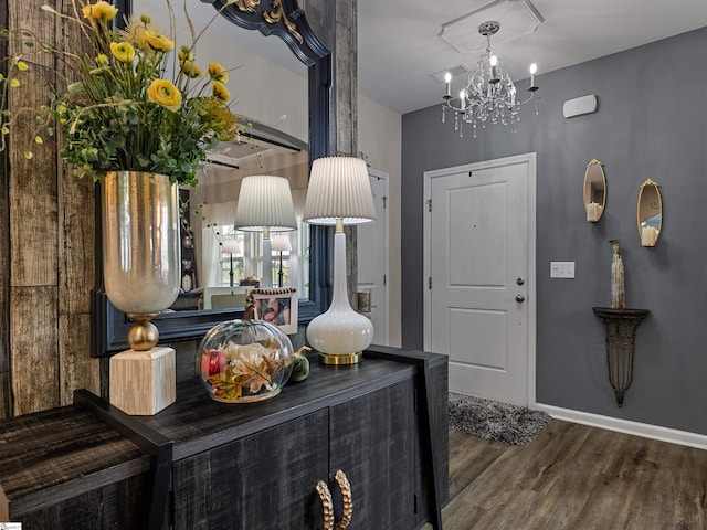 foyer entrance with a chandelier and dark wood-type flooring