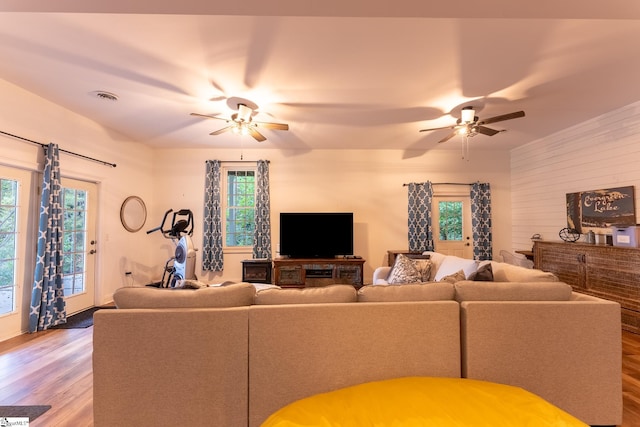 living room featuring ceiling fan, hardwood / wood-style flooring, and plenty of natural light