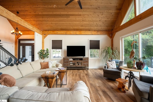 living room with ceiling fan with notable chandelier, hardwood / wood-style flooring, wood ceiling, and beam ceiling