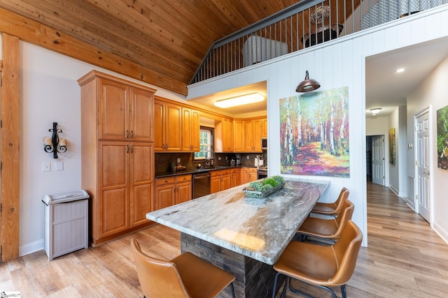 kitchen with backsplash, high vaulted ceiling, stainless steel appliances, a breakfast bar, and light wood-type flooring