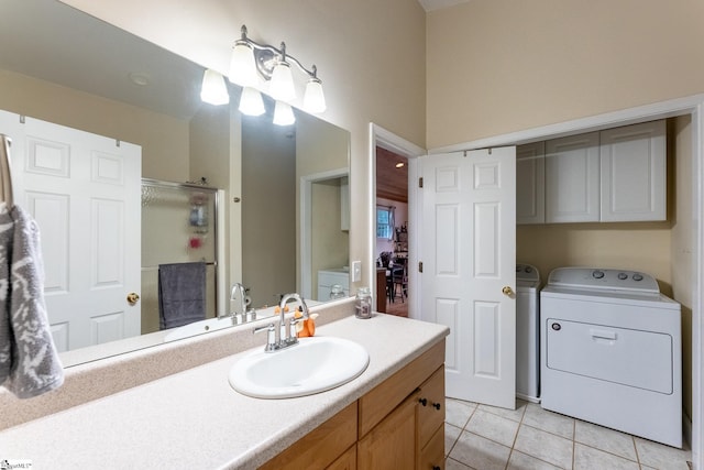 bathroom featuring a shower with door, vanity, tile patterned flooring, and washing machine and clothes dryer