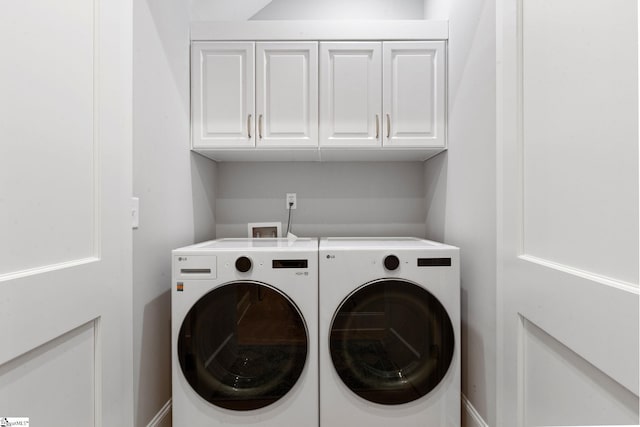 laundry room with separate washer and dryer and cabinets