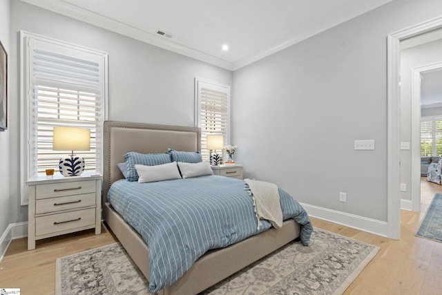 bedroom with ornamental molding and light wood-type flooring