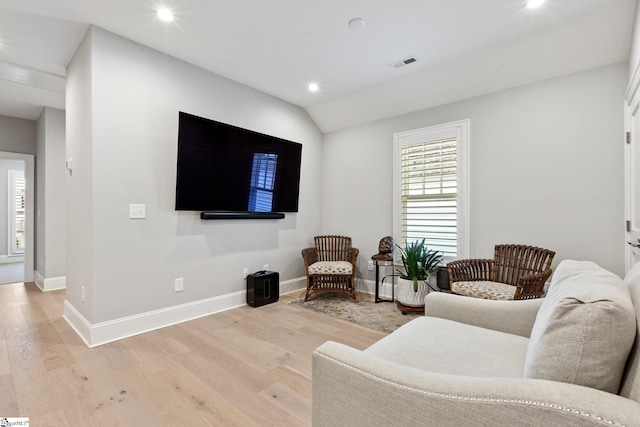 living room featuring light hardwood / wood-style flooring and lofted ceiling