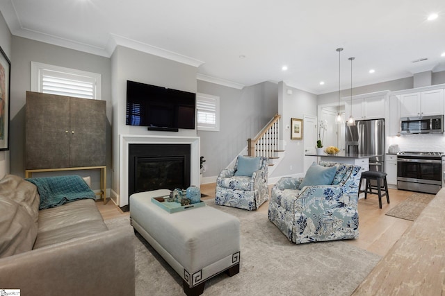 living room with light hardwood / wood-style flooring and ornamental molding