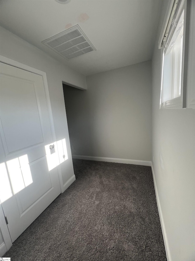 unfurnished room with dark carpet