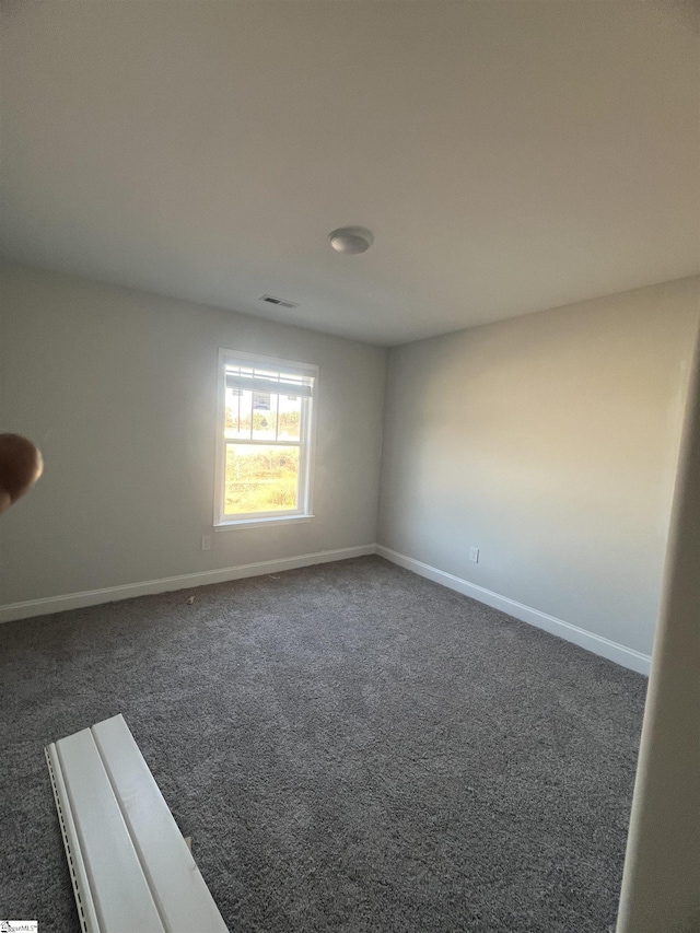 unfurnished room with dark carpet