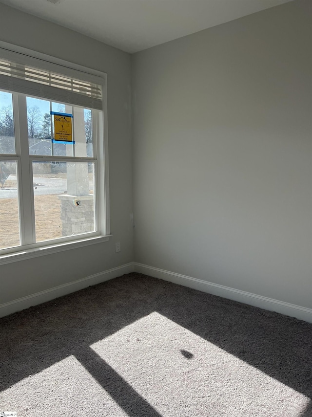 unfurnished room featuring dark carpet