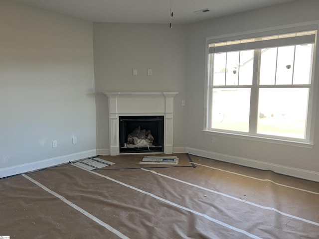 unfurnished living room with a healthy amount of sunlight and concrete flooring