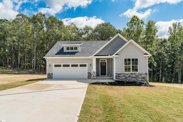 craftsman-style home with stone siding, an attached garage, driveway, and a front yard