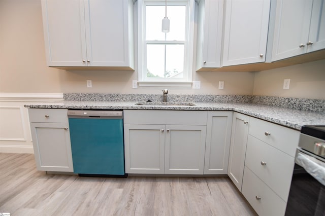 kitchen featuring dishwasher, a sink, light wood-style floors, light stone counters, and range
