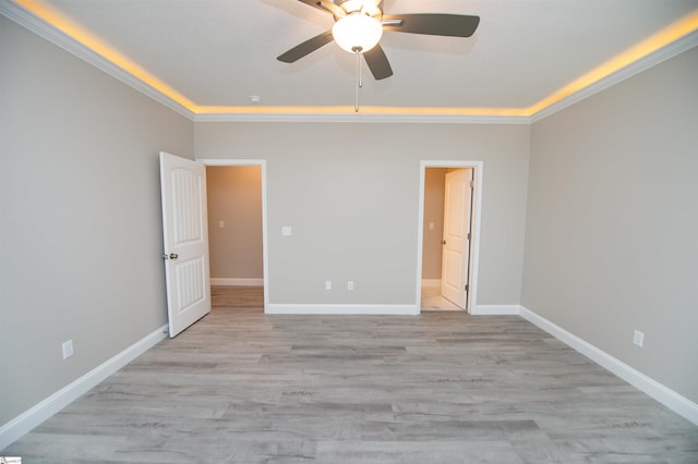 unfurnished bedroom featuring ornamental molding, baseboards, light wood finished floors, and a ceiling fan