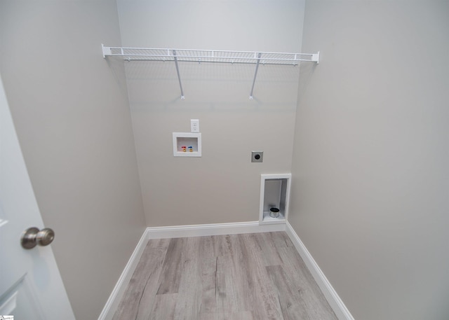 washroom with light wood-type flooring, washer hookup, hookup for an electric dryer, and baseboards