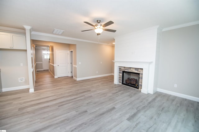 unfurnished living room with ceiling fan, ornamental molding, a fireplace, light wood-type flooring, and baseboards