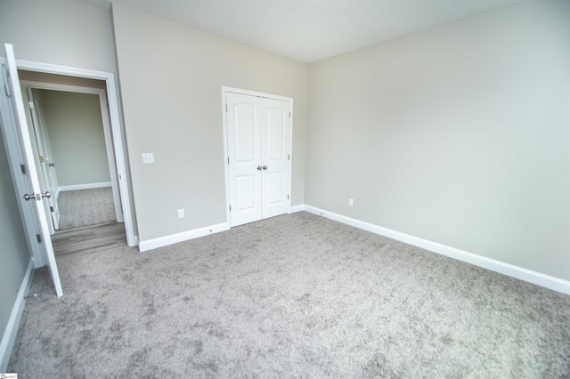 unfurnished bedroom with carpet, baseboards, and a closet