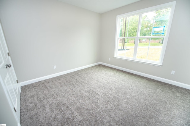 empty room featuring baseboards and carpet flooring