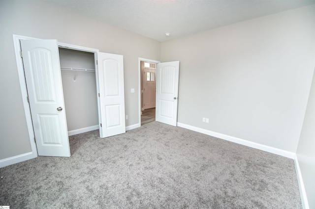 unfurnished bedroom with carpet, baseboards, and a closet