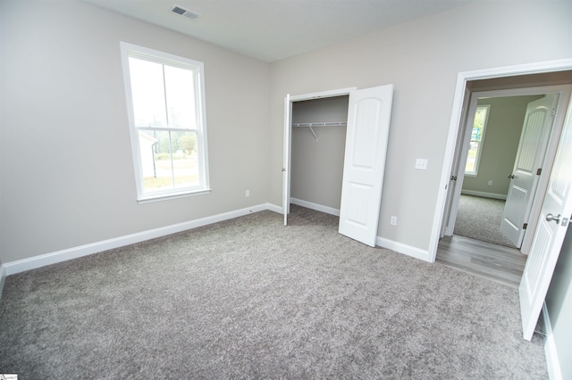 unfurnished bedroom with carpet flooring, baseboards, and a closet