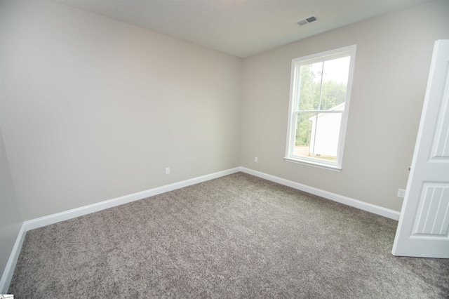 carpeted spare room featuring baseboards