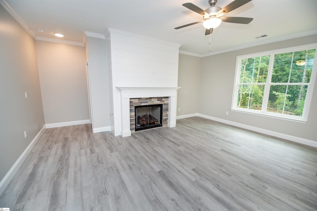 unfurnished living room with a fireplace, wood finished floors, ceiling fan, ornamental molding, and baseboards