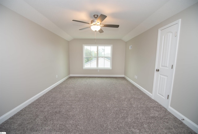 carpeted spare room featuring a ceiling fan, baseboards, and lofted ceiling