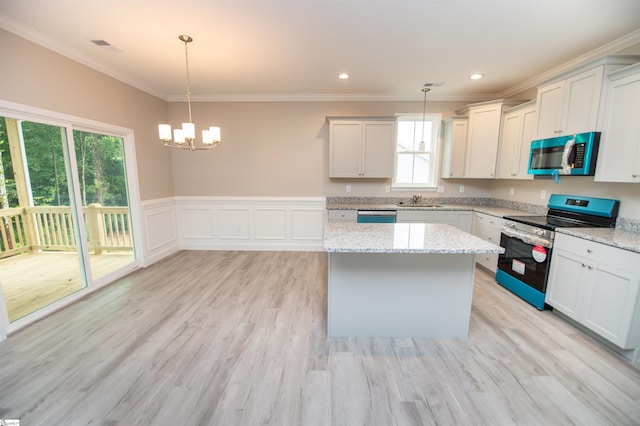 kitchen featuring appliances with stainless steel finishes, ornamental molding, a chandelier, light stone counters, and a kitchen island