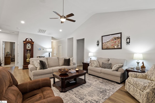 living room featuring ceiling fan, light wood-type flooring, and vaulted ceiling