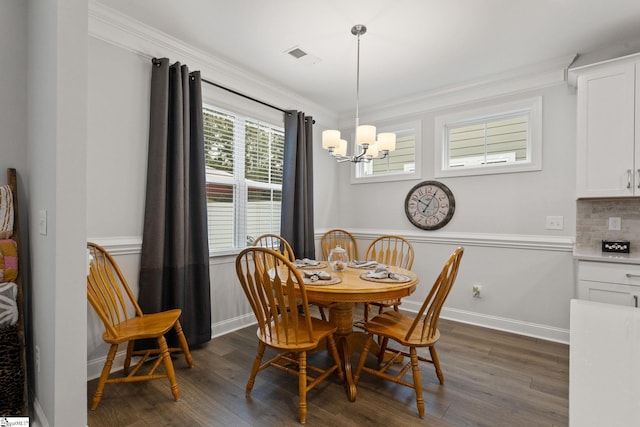 dining area featuring a chandelier, dark hardwood / wood-style floors, and crown molding