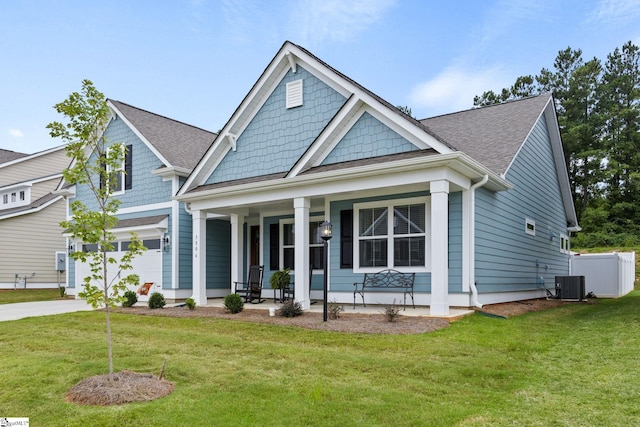 craftsman-style house with a front lawn, central AC unit, and covered porch