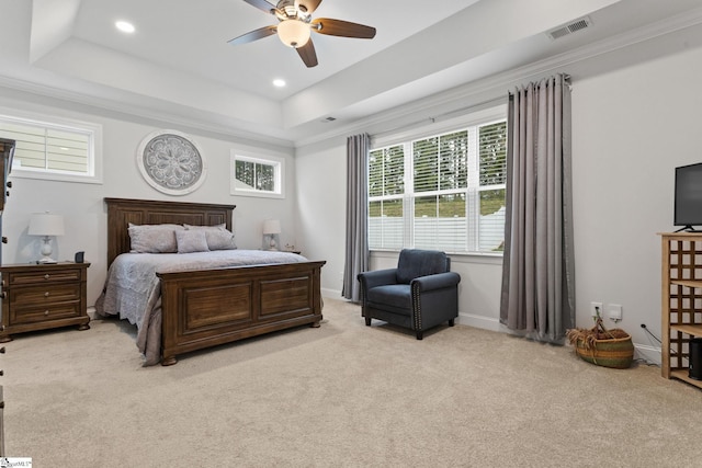 bedroom with a raised ceiling, ceiling fan, light colored carpet, and crown molding