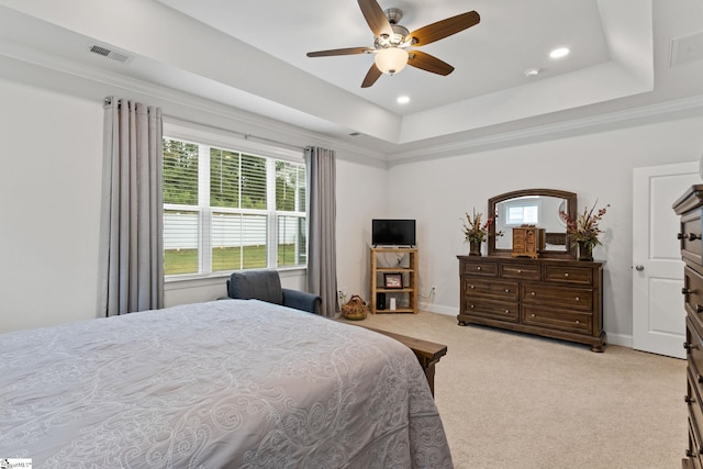 bedroom with a raised ceiling, crown molding, ceiling fan, and light colored carpet