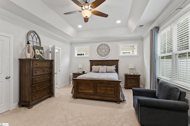 carpeted bedroom featuring multiple windows, crown molding, a tray ceiling, and ceiling fan