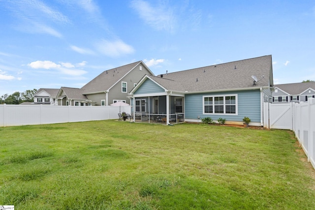 back of house featuring a sunroom and a lawn