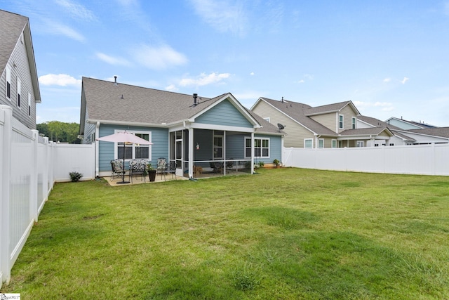 rear view of property featuring a sunroom, a patio, and a lawn