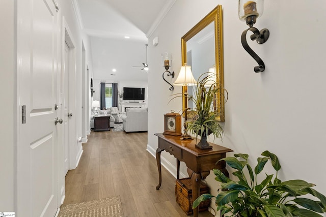 hallway featuring light wood-type flooring and ornamental molding