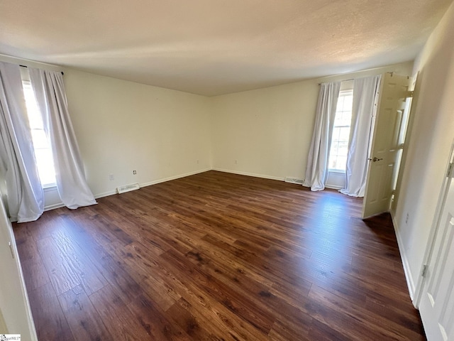 empty room featuring dark hardwood / wood-style floors and a healthy amount of sunlight