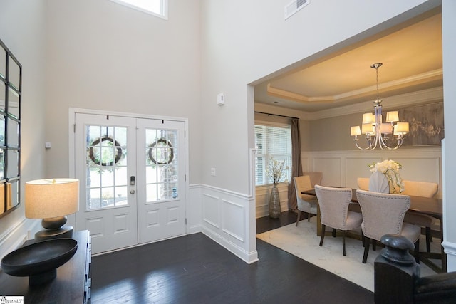 entrance foyer featuring french doors, plenty of natural light, dark hardwood / wood-style floors, and a chandelier