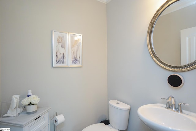 bathroom featuring crown molding, sink, and toilet