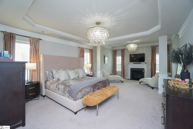 bedroom featuring light carpet, a raised ceiling, and multiple windows