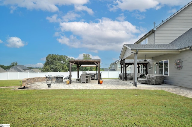 view of yard featuring ceiling fan, a patio area, and an outdoor fire pit