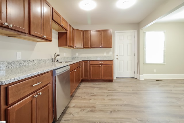 kitchen featuring light stone counters, dishwasher, light hardwood / wood-style flooring, and sink