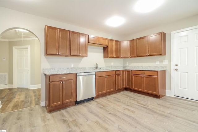 kitchen with light stone counters, ornamental molding, sink, stainless steel dishwasher, and light hardwood / wood-style floors