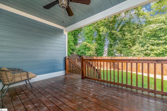 deck featuring ceiling fan and a lawn