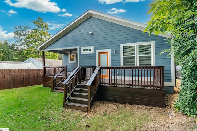 rear view of house with a deck and a yard