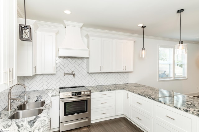 kitchen featuring premium range hood, sink, decorative light fixtures, white cabinetry, and electric stove