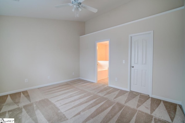 unfurnished bedroom featuring light carpet, ensuite bath, and ceiling fan