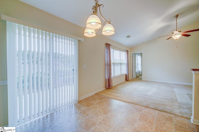 carpeted spare room featuring ceiling fan with notable chandelier and lofted ceiling