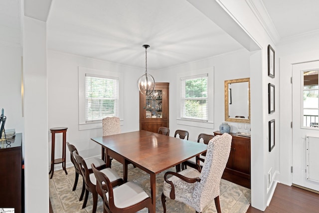 dining space featuring a chandelier, hardwood / wood-style floors, crown molding, and a healthy amount of sunlight