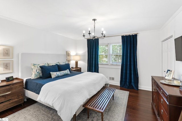 bedroom featuring dark hardwood / wood-style floors, a chandelier, and crown molding